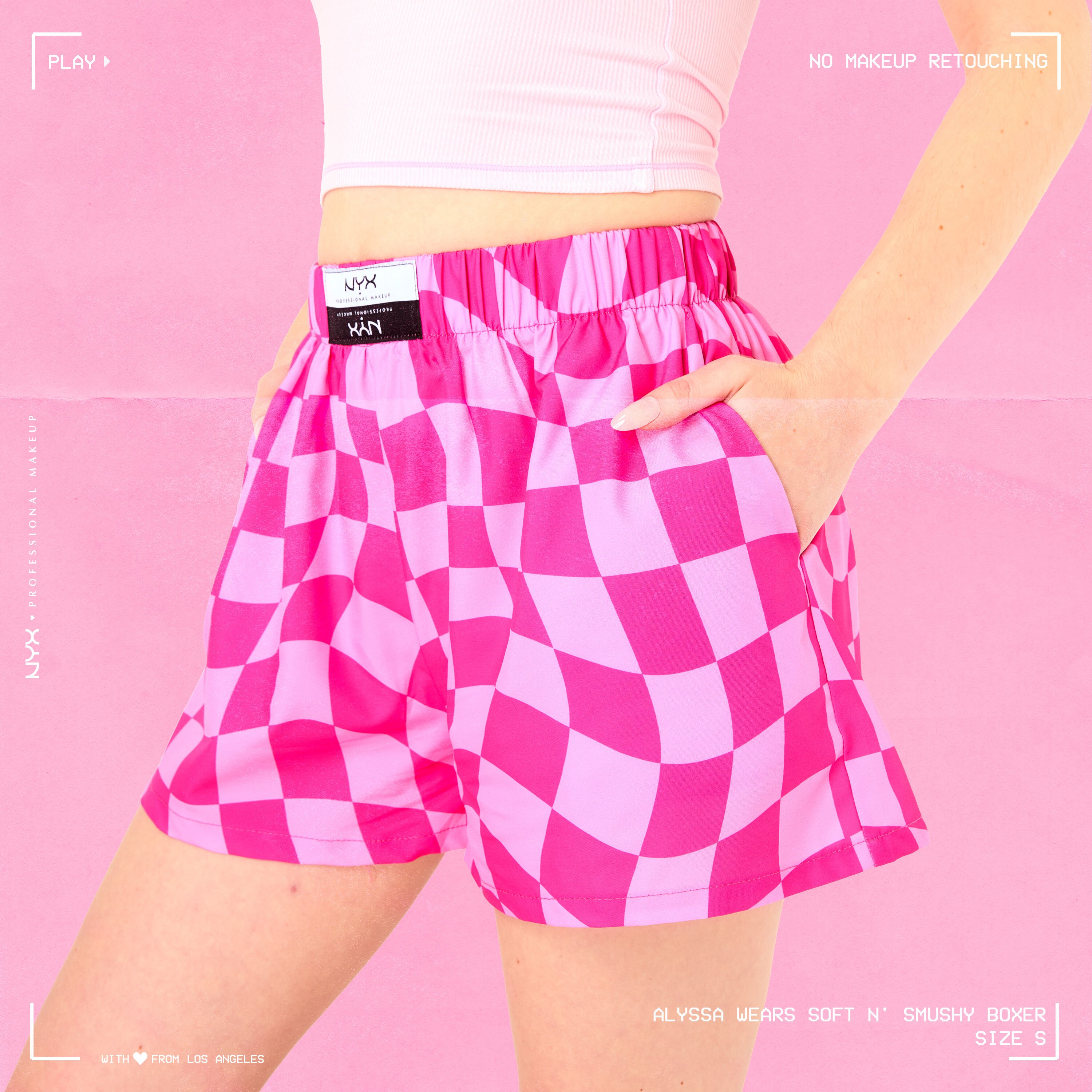 Model wearing Soft n' Smushy Pink Checker Print Boxers in a size small, standing diagonally