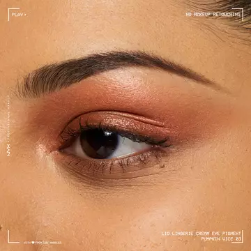 Close-up of an eye wearing NYX Professional Makeup Party Animals Lid Lingerie Cream Eye Pigment in Pumpkin Vice, a deep metallic orange shade.
