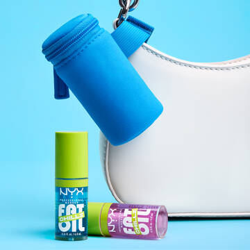 Blue Lip Gloss Pouch attached to white purse with 2 Fat Oil Lip Drip Chillz Lip Oils sitting in front