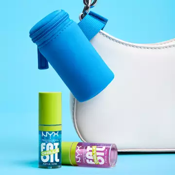 Blue Lip Gloss Pouch attached to white purse with 2 Fat Oil Lip Drip Chillz Lip Oils sitting in front