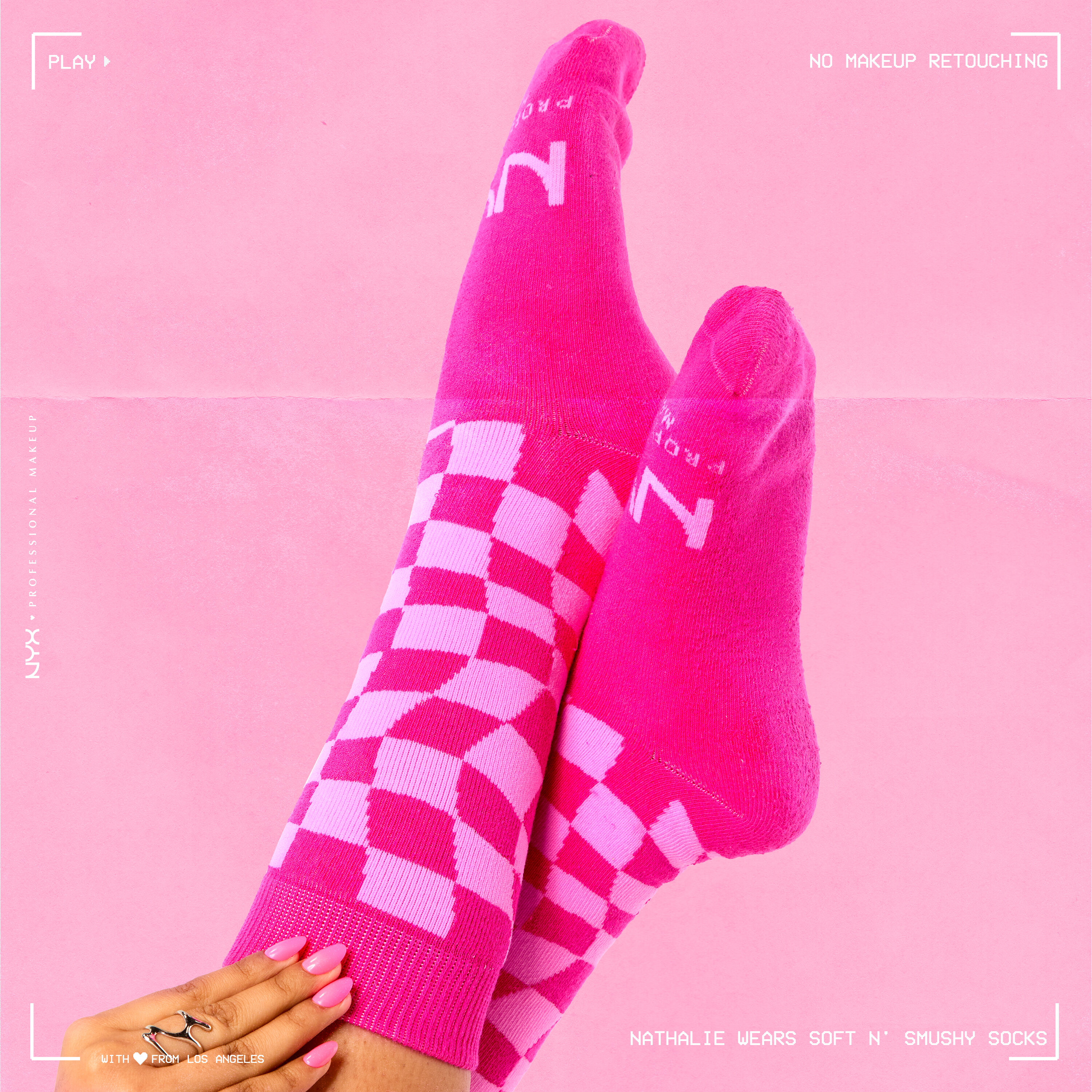 Closeup of models lower legs wearing Soft n' Smushy Pink Checker Print Socks against a pink background