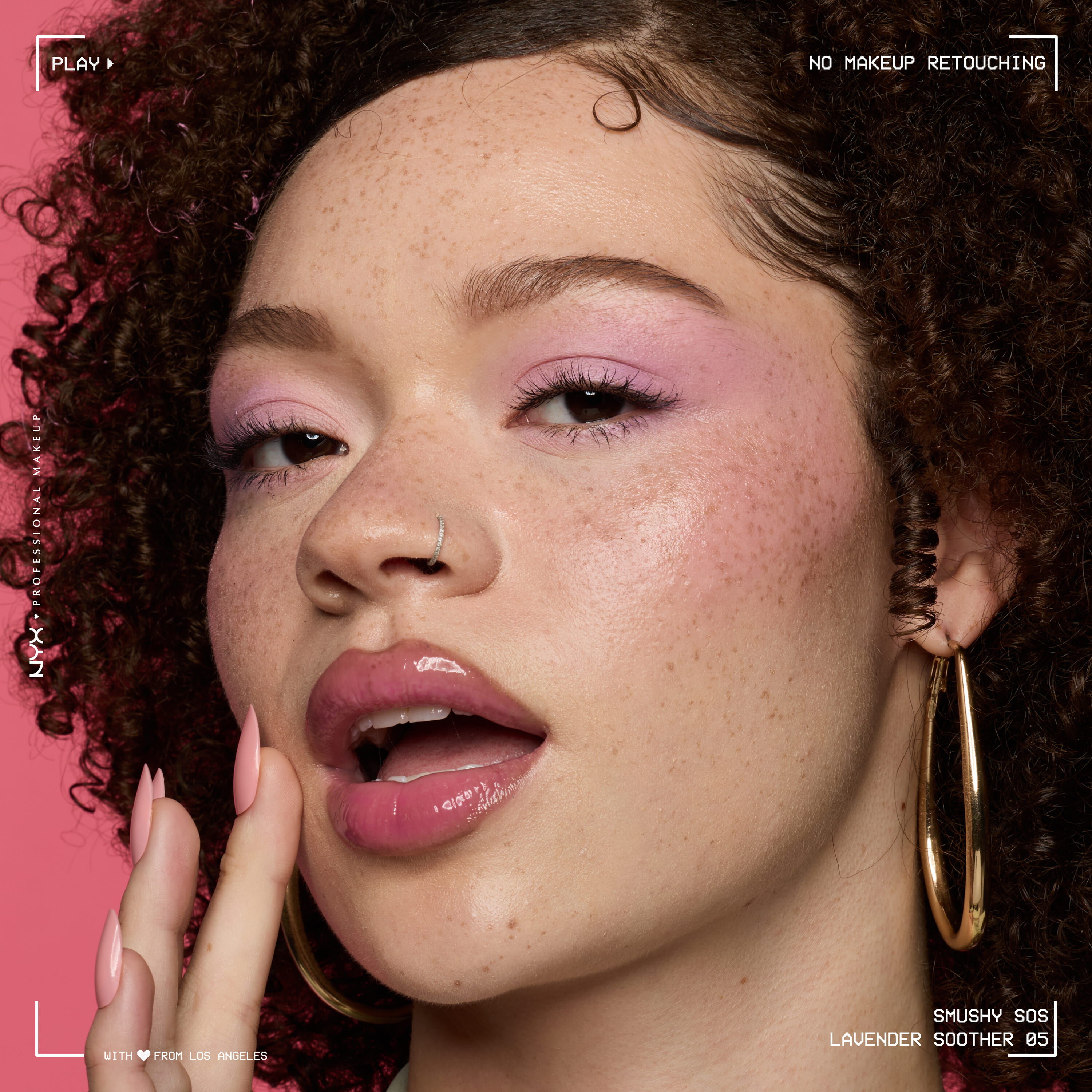 Close-up beauty portrait of a model wearing NYX Smushy SOS Hydrating Lip Mask in Lavender Soother, shown with a glossy lip finish against a pink background.