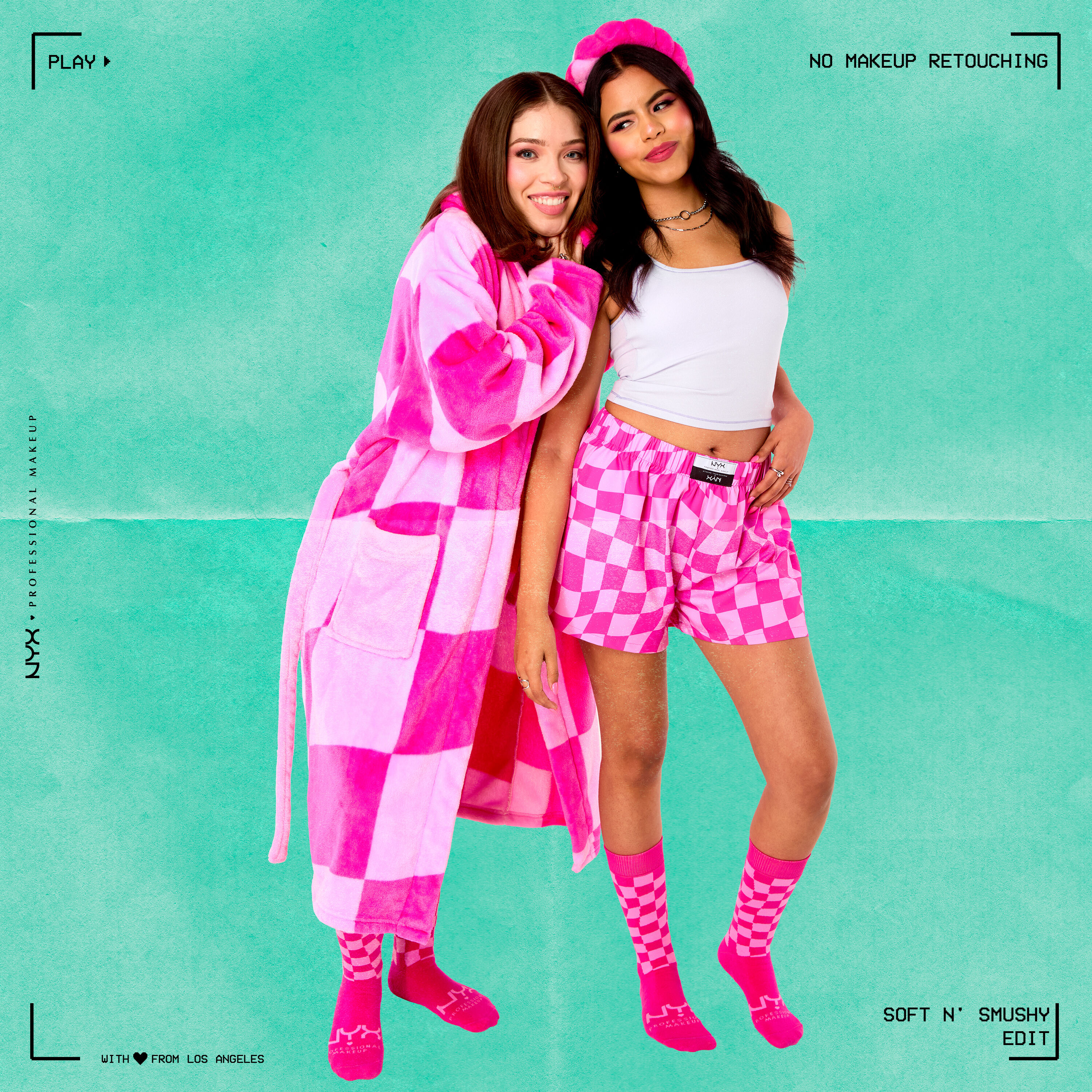 A model wearing Soft n' Smushy socks, boxers, & robe merch, with an arm around another model wearing merch socks, boxers, & a headband