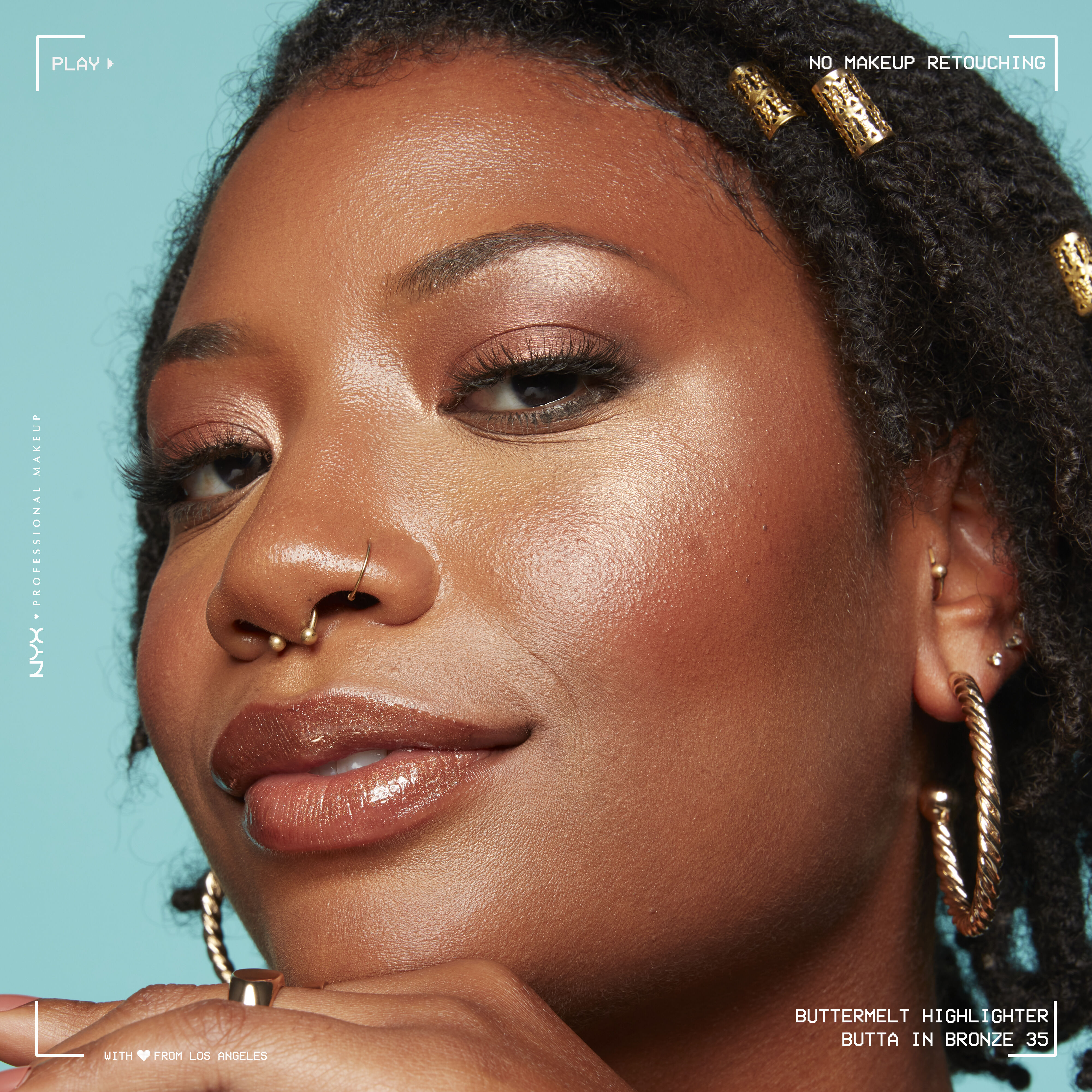 Model looking at the camera and smiling, wearing Buttermelt Highlighter in shade Butta In Bronze, a bronze gold shade