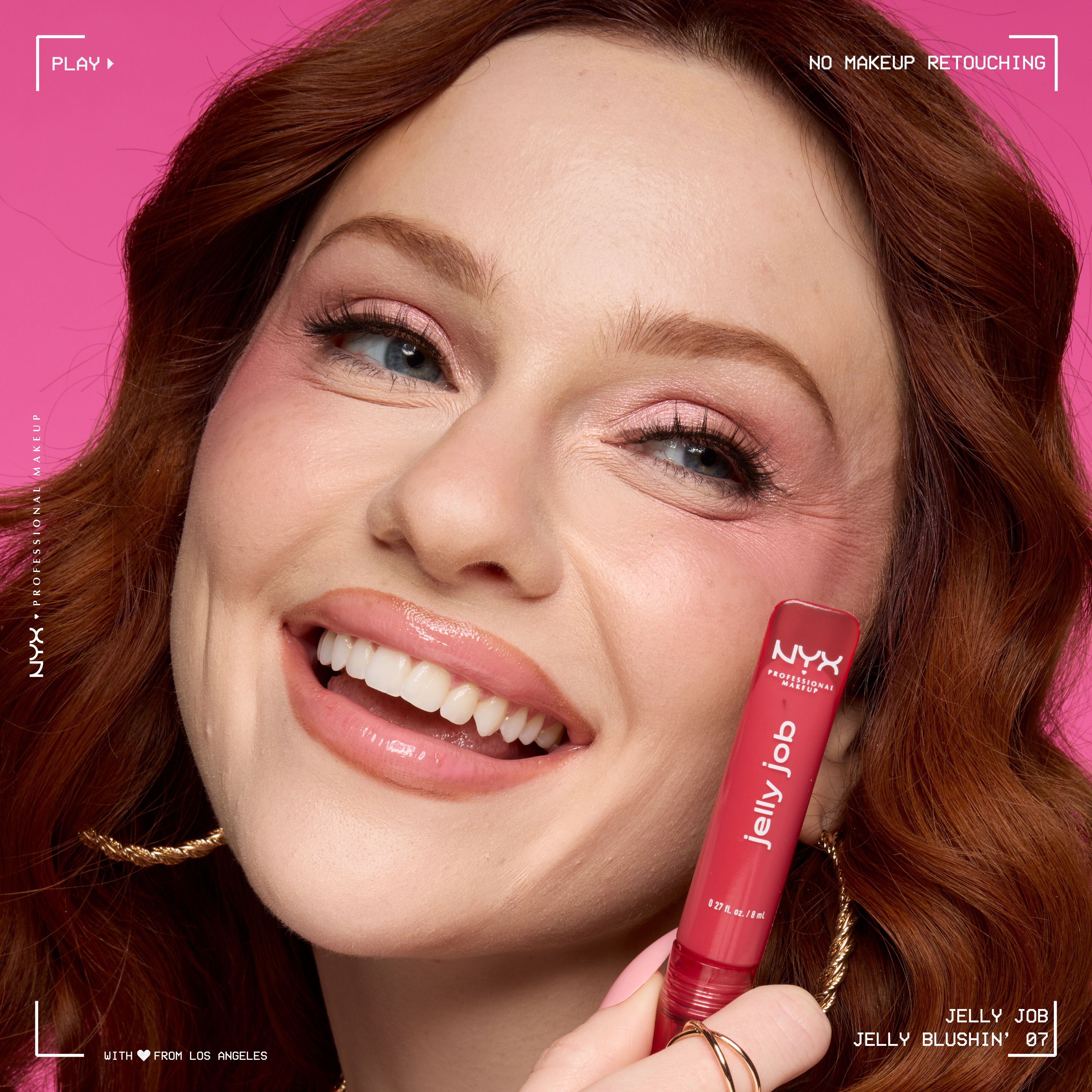 Smiling model wearing Jelly Job Jelly Lip Gloss in shade 'Jelly Blushin''