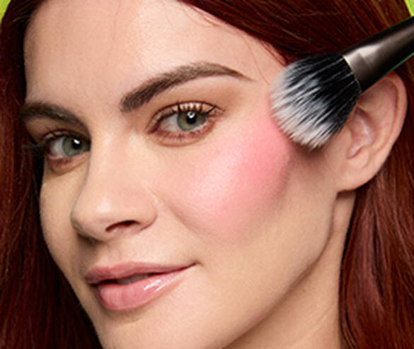 Closeup of woman blending out Fat Cheeks Juicy Blush liquid blush with a fluffy makeup brush