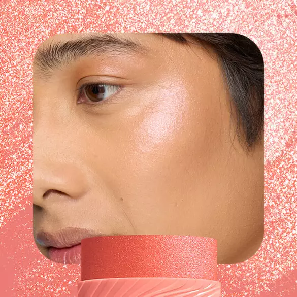 Model with coral-peach glow wearing NYX Buttermelt Stix in Melt Down 09 showing warm luminous sheen
