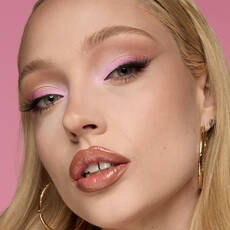 Model wearing NYX Make ’Em Wonder™ Soft Matte Foundation in shade 07 Light Ivory with soft pink eye makeup and glossy lips.