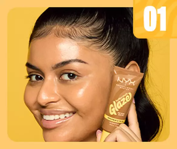 woman smiling and holding Buttermelt Glaze Skin Tint