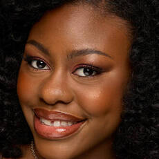 Model wearing NYX Make ’Em Wonder™ Foundation in shade 35 Soft Mocha with warm blush and glossy lips.