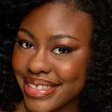 Model wearing NYX Make ’Em Wonder™ Foundation in shade 35 Soft Mocha with warm blush and glossy lips.