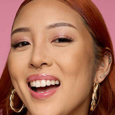 Model wearing NYX Make ’Em Wonder™ Foundation in shade 16 Natural Beige with glossy lips and pink shimmer eyes.