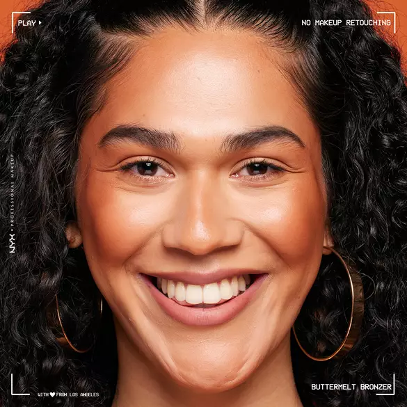 Model looking at the camera and smiling, wearing Buttermelt Bronzer