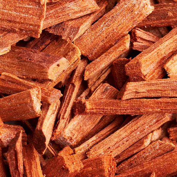 Close-up of chopped cedarwood to represent one of the bottom notes of Juicy Boo fragrance.