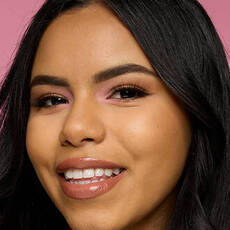 Model wearing NYX Make ’Em Wonder™ Foundation in shade 19 Warm Beige with soft glow and glossy neutral lips.