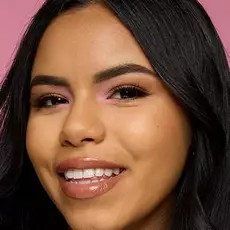 Model wearing NYX Make ’Em Wonder™ Foundation in shade 19 Warm Beige with soft glow and glossy neutral lips.