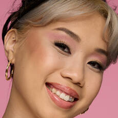 Model wearing NYX Make ’Em Wonder™ Foundation in shade 12 Natural with rosy blush and pink shimmer eyeshadow.