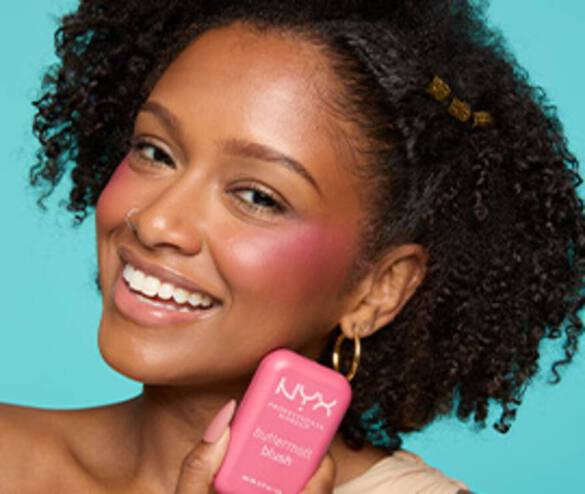 Smiling model looking at the camera and holding Buttermelt Blush in shade 07 Butta With Time