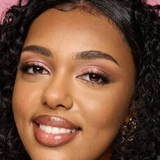 Model wearing NYX Make ’Em Wonder™ Foundation in shade 30 Light Nutmeg with bronzed glow and glossy nude lips.