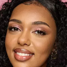 Model wearing NYX Make ’Em Wonder™ Foundation in shade 30 Light Nutmeg with bronzed glow and glossy nude lips.