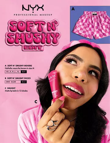 A promotional image for NYX Professional Makeup's "Soft N' Shushy Edit," featuring pink checkered boxers, socks, and a person holding a NYX Soft Matte Lip Cream in pink packaging.
