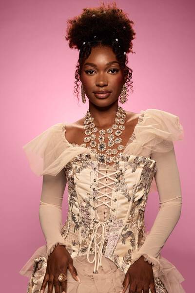 Model wearing Frankenstein’s monster Halloween makeup look, with green face & fake stitch makeup