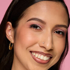 Model wearing NYX Make ’Em Wonder™ Foundation in shade 18 Golden Light with pink eyeshadow and natural glow.