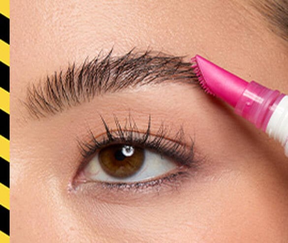 Closeup of model back backcombing eyebrow with The Brow Glue Crazy Lift