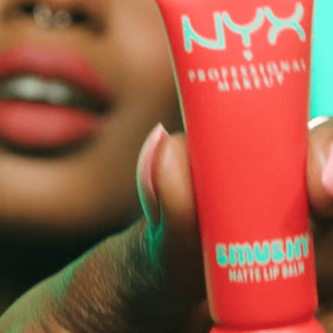 Video thumbnail of a model holding and wearing Smushy Matte Lip Balm