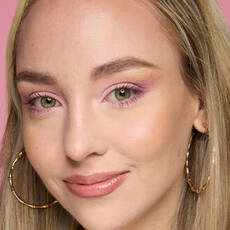Model wearing NYX Make ’Em Wonder™ Foundation in shade 05 Fair Ivory with glowy blush and pink shimmer eyes.