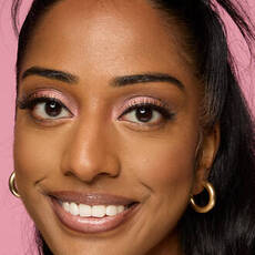 Model wearing NYX Make ’Em Wonder™ Foundation in shade 29 Warm Pecan with soft glow and natural pink tones.