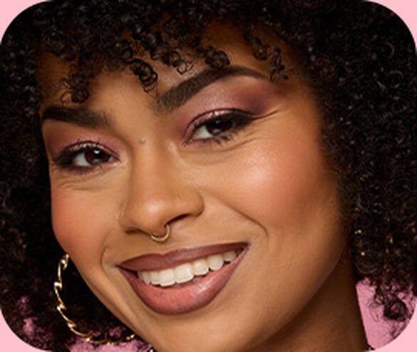Close-up of smiling model with a completed face makeup look created using the NYX Professional Makeup Wonder™ line