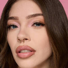 Model wearing NYX Make ’Em Wonder™ Foundation in shade 06 Light with pink eyeshadow and glossy lips.