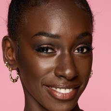 Model wearing NYX Make’em Wonder™ Foundation in shade 45 Rich Cocoa with matte finish and dark shimmer eyeshadow.