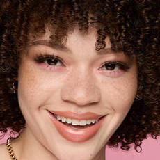 Model wearing NYX Make ’Em Wonder™ Foundation in shade 03 Fair with peachy blush and pink shimmer eyeshadow.