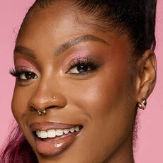 Model wearing NYX Make ’Em Wonder™ Foundation in shade 36 Warm Rich with pink shimmer eyes and radiant glow.
