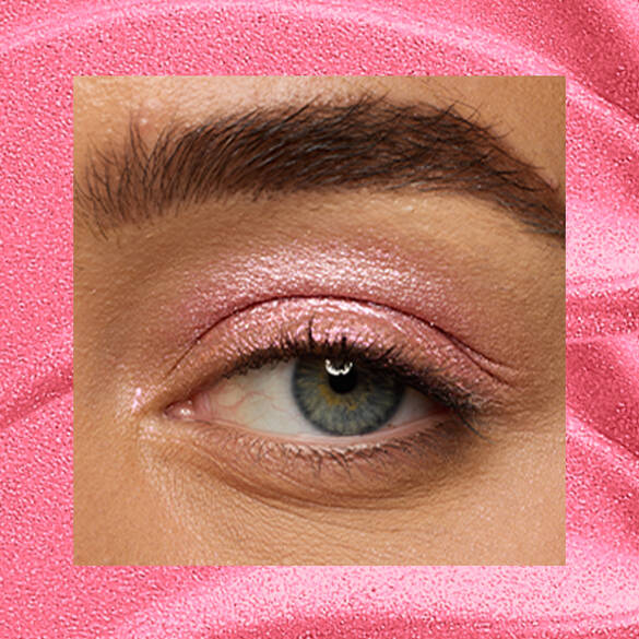 Close-up of a fair-skinned eye wearing 08 Push-Up Pink, a bubblegum-pink metallic cream eyeshadow from NYX Professional Makeup Lid Lingerie, on a matching pink shimmer backdrop.