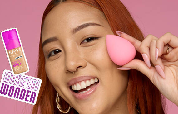 Model holding pink makeup sponge and NYX Make ’Em Wonder™ Foundation in shade 07 Light Ivory, text overlay “Make ’Em Wonder™.”