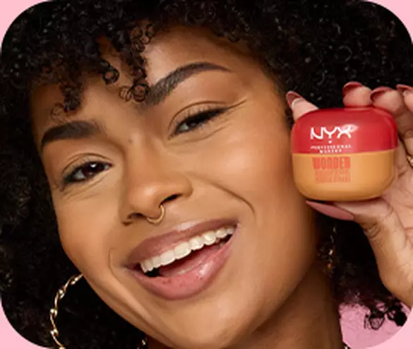 Close-up of model posing and smiling while holding Wonder Snatch™ Lifting Setting Powder near face