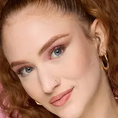 Model wearing NYX Make ’Em Wonder™ Foundation in shade 02 Fair Porcelain with pink eyeshadow and glossy nude lips.