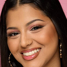 Model wearing NYX Make ’Em Wonder™ Foundation in shade 20 Classic Tan with bronzed cheeks and glossy nude lips.