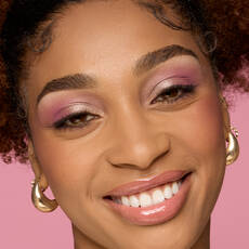 Model wearing NYX Make ’Em Wonder™ Foundation in shade 21 Neutral Tan with pink shimmer eyeshadow and glossy lips.