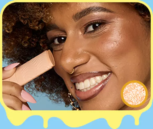 Model holding NYX Buttermelt Stix in Let Me Melt 08 on nose bridge for radiant golden highlight