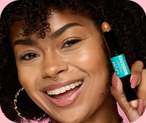 Close-up of model posing and smiling while holding NYX Professional Makeup Wonder™ Stick Contour Stick