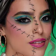 NYX Professional Makeup turquoise skeleton Halloween look with vivid blue eye makeup, black contour lines and painted skeletal teeth.