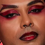 NYX Professional Makeup colorful Halloween look with neon yellow and green eyeshadow, flushed cheeks and a glossy pink lip.