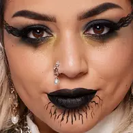 NYX Professional Makeup Halloween gothic look with dramatic winged eyeliner, black lipstick, dark contouring and facial piercings.